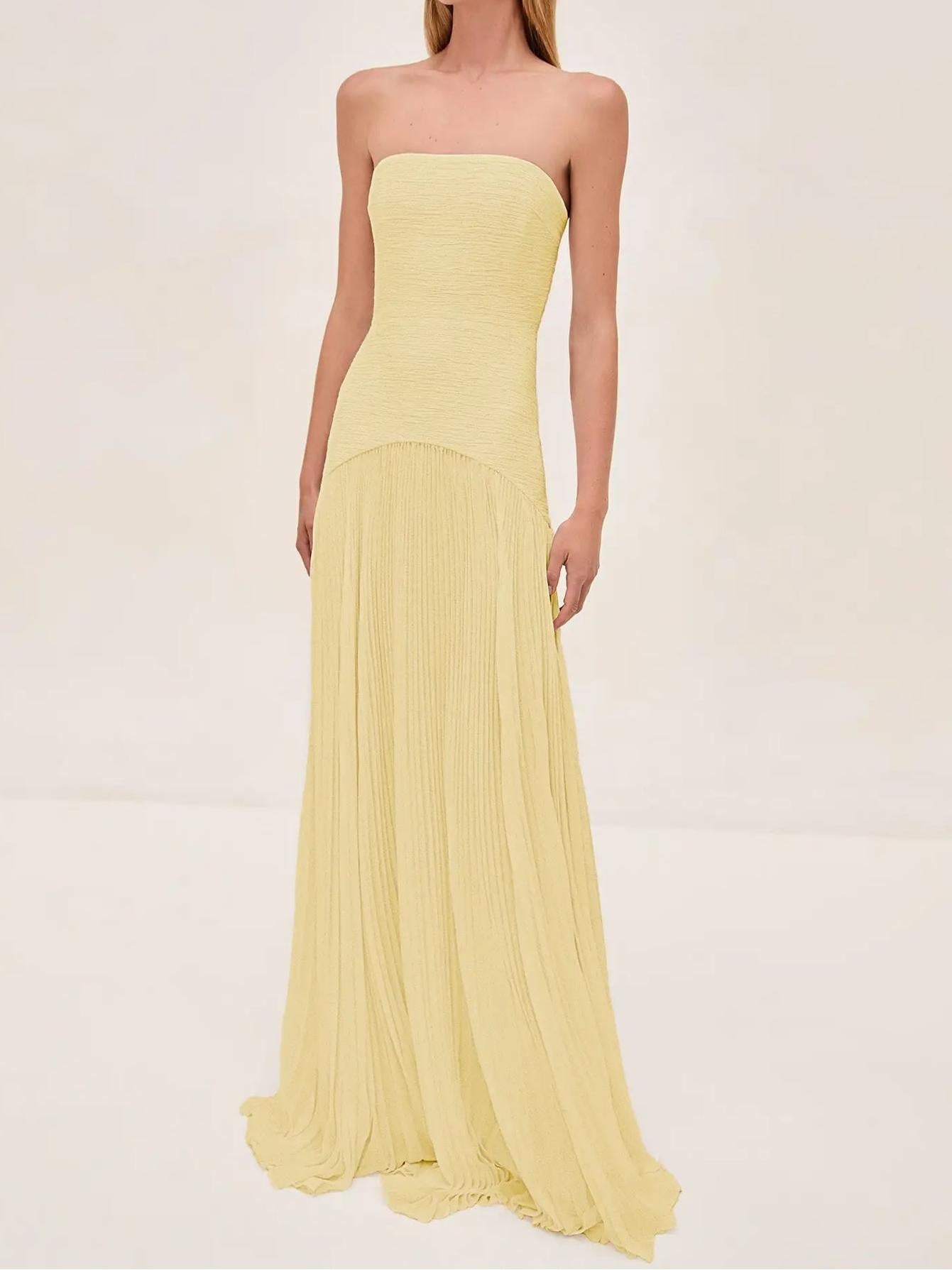 Jesie-London Clara women's strapless pleated maxi wedding guest dress displayed on a hanger. Elegant white gown with flowing pleats.