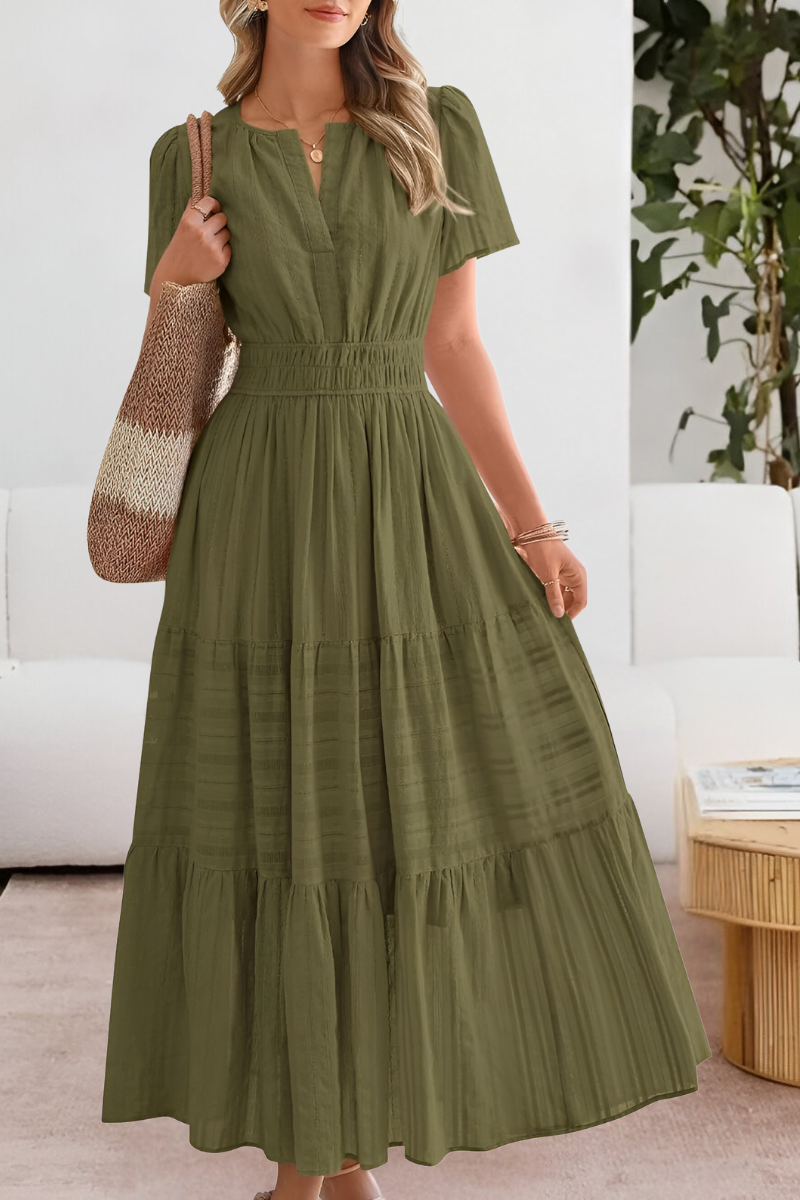 Jesie-London Alice women's boho short sleeve smocked midi dress hanging on a hanger with floral patterns and flowing fabric.