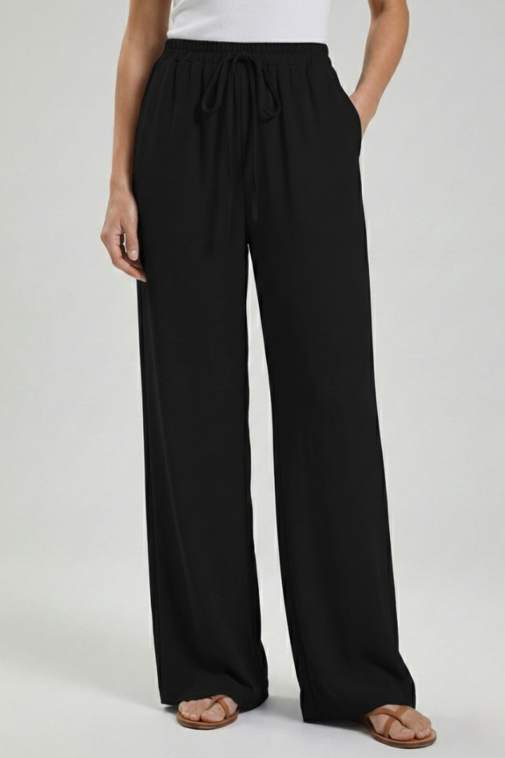 Catherine women's palazzo trousers by Jesie-London with drawstring waist and side pockets, flowing wide-leg design.