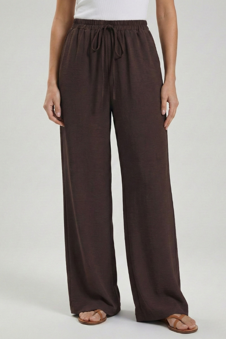 Women’s palazzo trousers by Jesie-London with a drawstring waist and side pockets, featuring a relaxed, flowing fit.