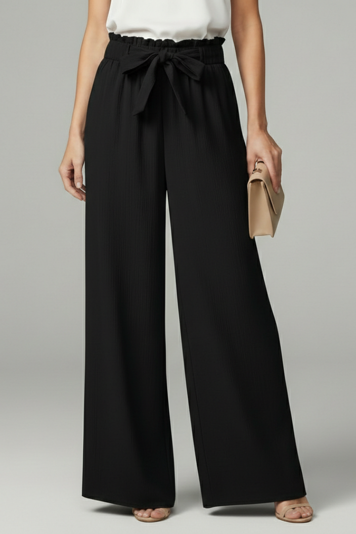 Women’s Charlotte palazzo trousers by Jesie-London featuring wide legs and a tie belt, shown in a stylish, flowing fabric.