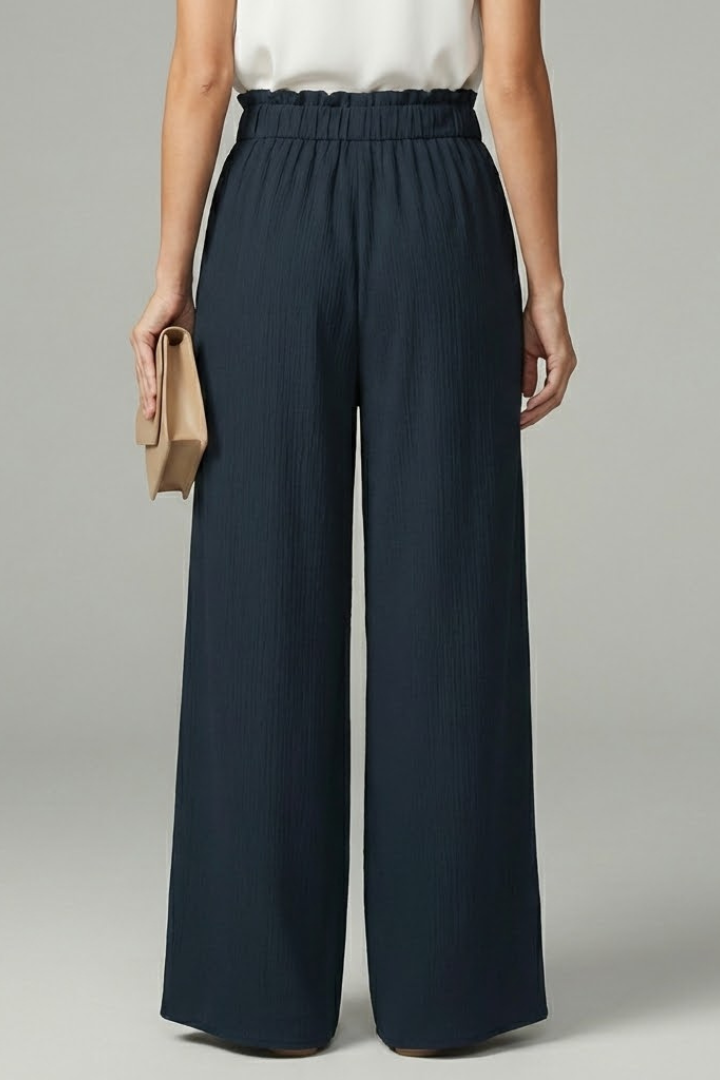 Women’s Charlotte palazzo trousers by Jesie-London featuring a tie belt and wide-leg design, shown in a stylish, flowing fabric.