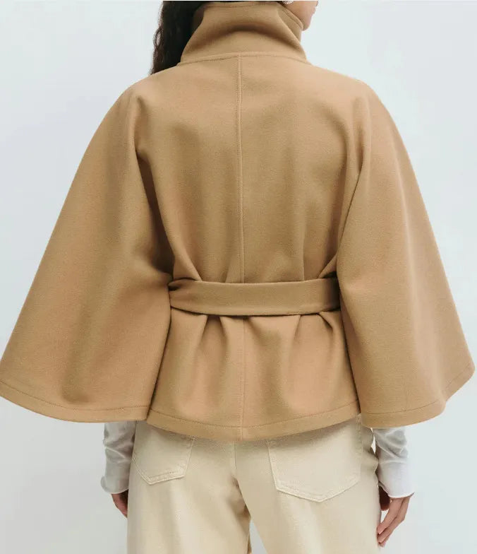 Women's spring belted high-neck cape coat by Jesie-London featuring a funnel neck, waist belt, and cape sleeves.