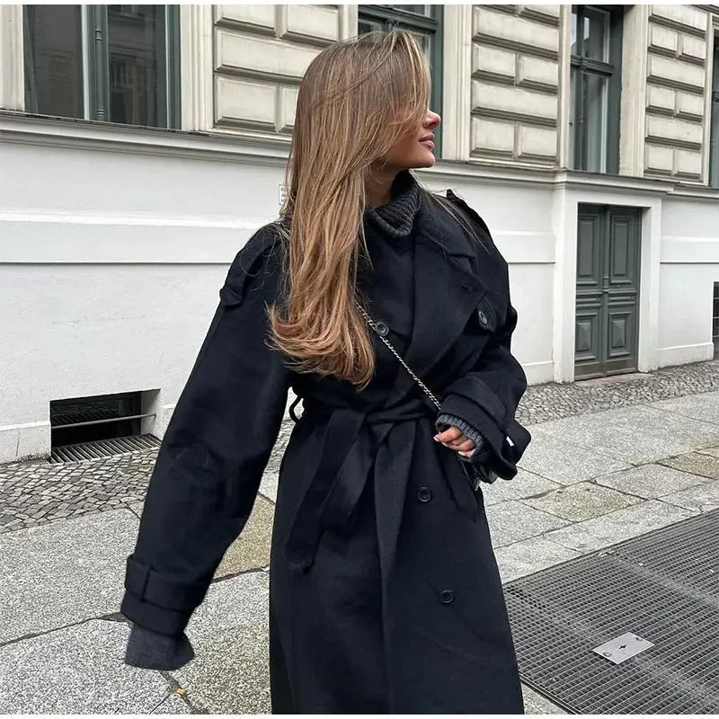 Elsie women's double-breasted trench coat by Jesie-London, stylish beige coat with classic collar and belt, hanging on a wooden hanger.