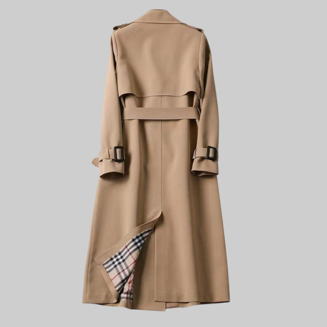 Women’s long belted trench coat by Jesie-London featuring double-breasted design and classic style, shown on a model.