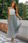 Light grey women's halter maxi dress with open back for wedding guests, styled for elegant occasions.