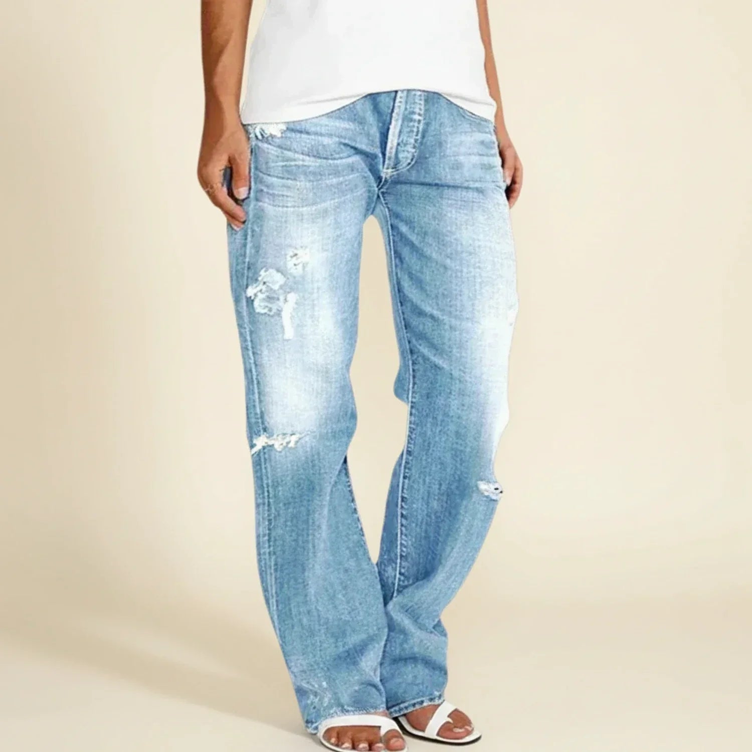 Women’s ripped high-rise straight jeans by Jesie-London featuring distressed detailing and a classic fit, worn by a model standing outdoors.