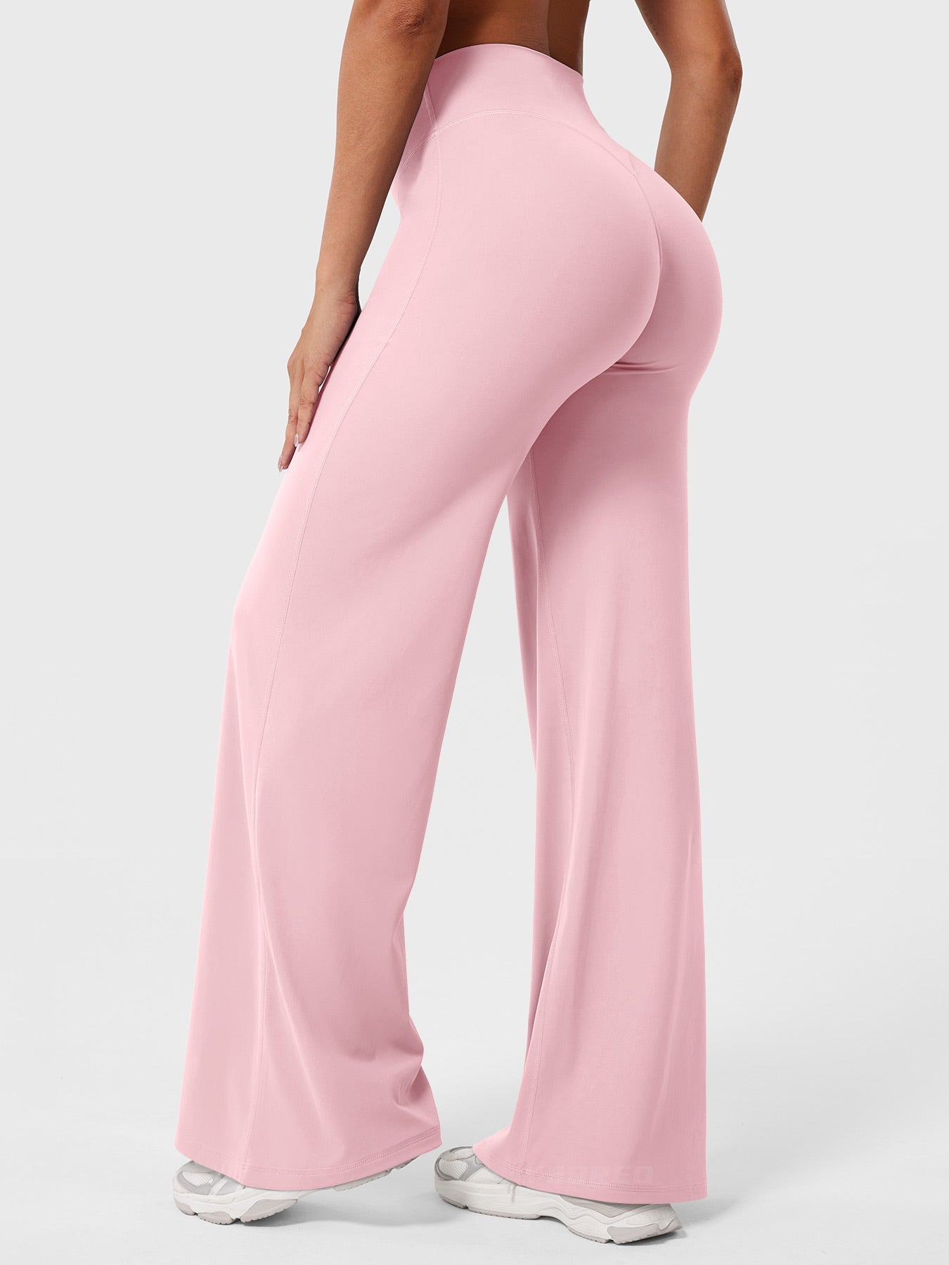 Light pink women's high waist flared pants from Jesie-London's Millie summer collection, styled with a relaxed fit and wide leg opening.