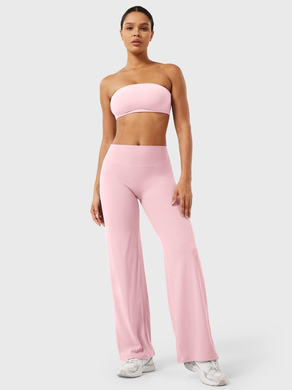 Light pink high-waist flared pants for women from Jesie-London's Millie summer collection, shown on a model.